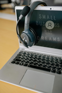 Laptop on desk with headphone hanging on screen